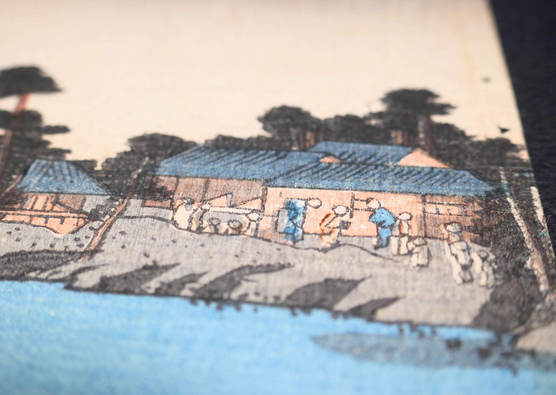 Détail du paysage au bord de l’eau avec maisons, arbres et silhouettes, extrait d’une estampe japonaise ancienne de Kunisada Toyokuni III.