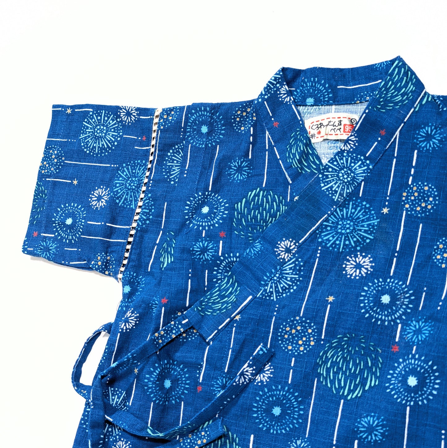 Manche et emmanchure du jinbei enfant bleu, tissu coton à motifs feux d’artifice japonais.