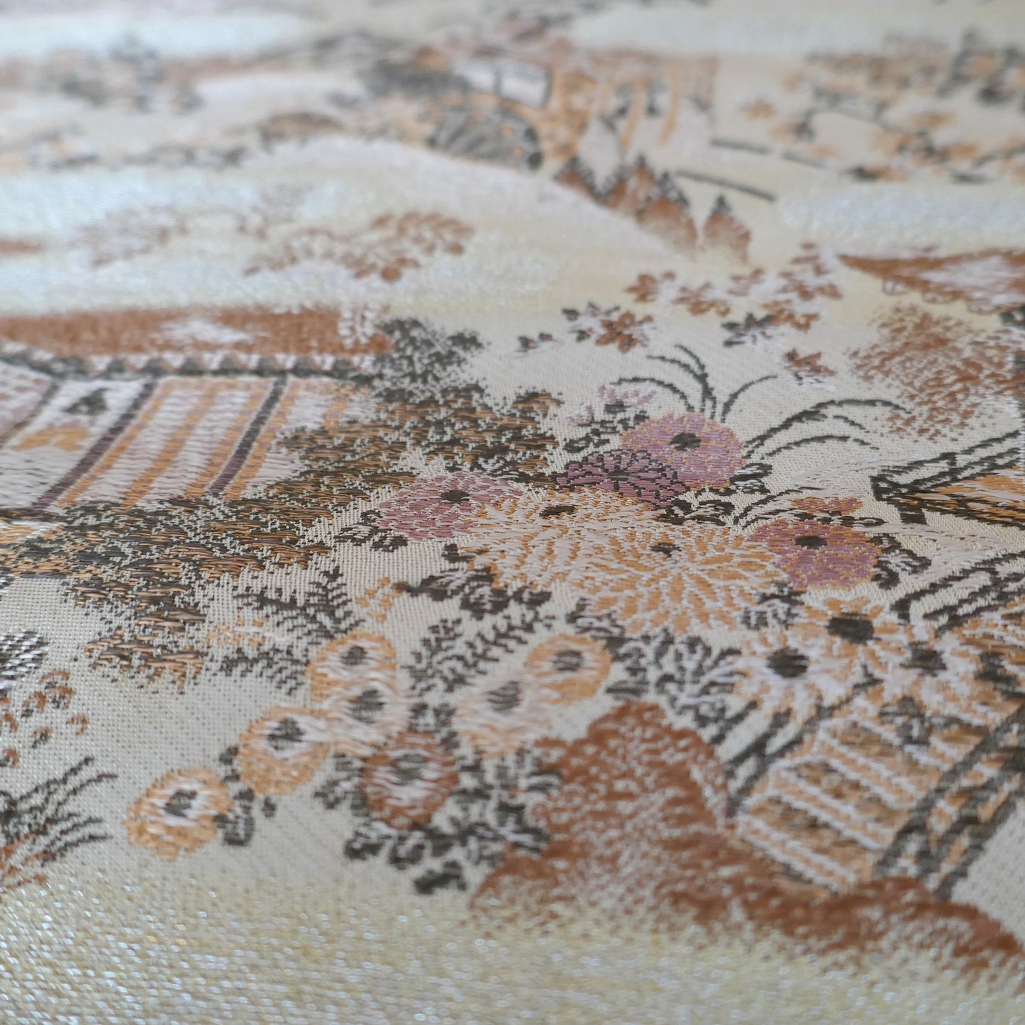 Texture en gros plan du tissu brocart en soie d’un obi à décor de paysage japonais