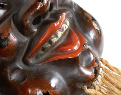 Détail du sourire et du menton d’un masque japonais de Daikoku en laque sèche kanshitsu, avec barbe en fibres végétales.