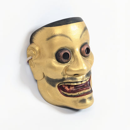 Vue trois-quarts d’un masque japonais traditionnel Ōtobide aux yeux globuleux et à la bouche ouverte