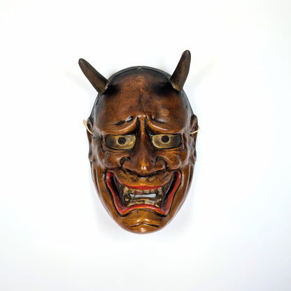 Masque japonais de théâtre Nô en céramique vu de face, éclairage dramatique traditionnel