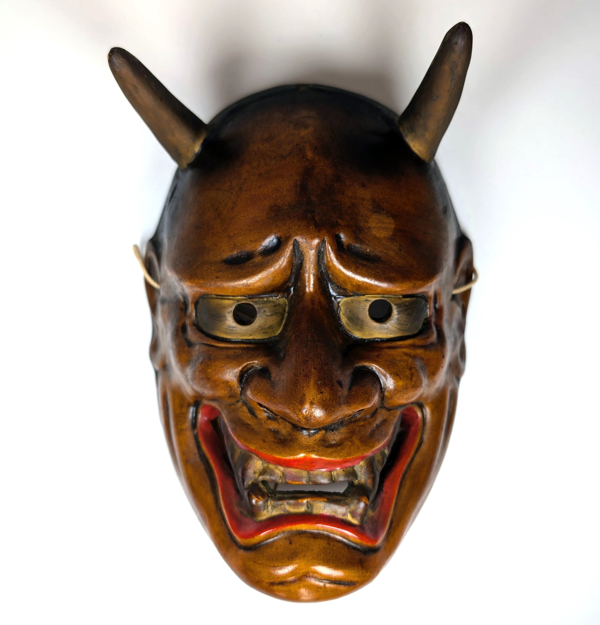 Gros plan sur le visage d’un masque de théâtre Nô japonais, détails expressifs mis en valeur par la lumière