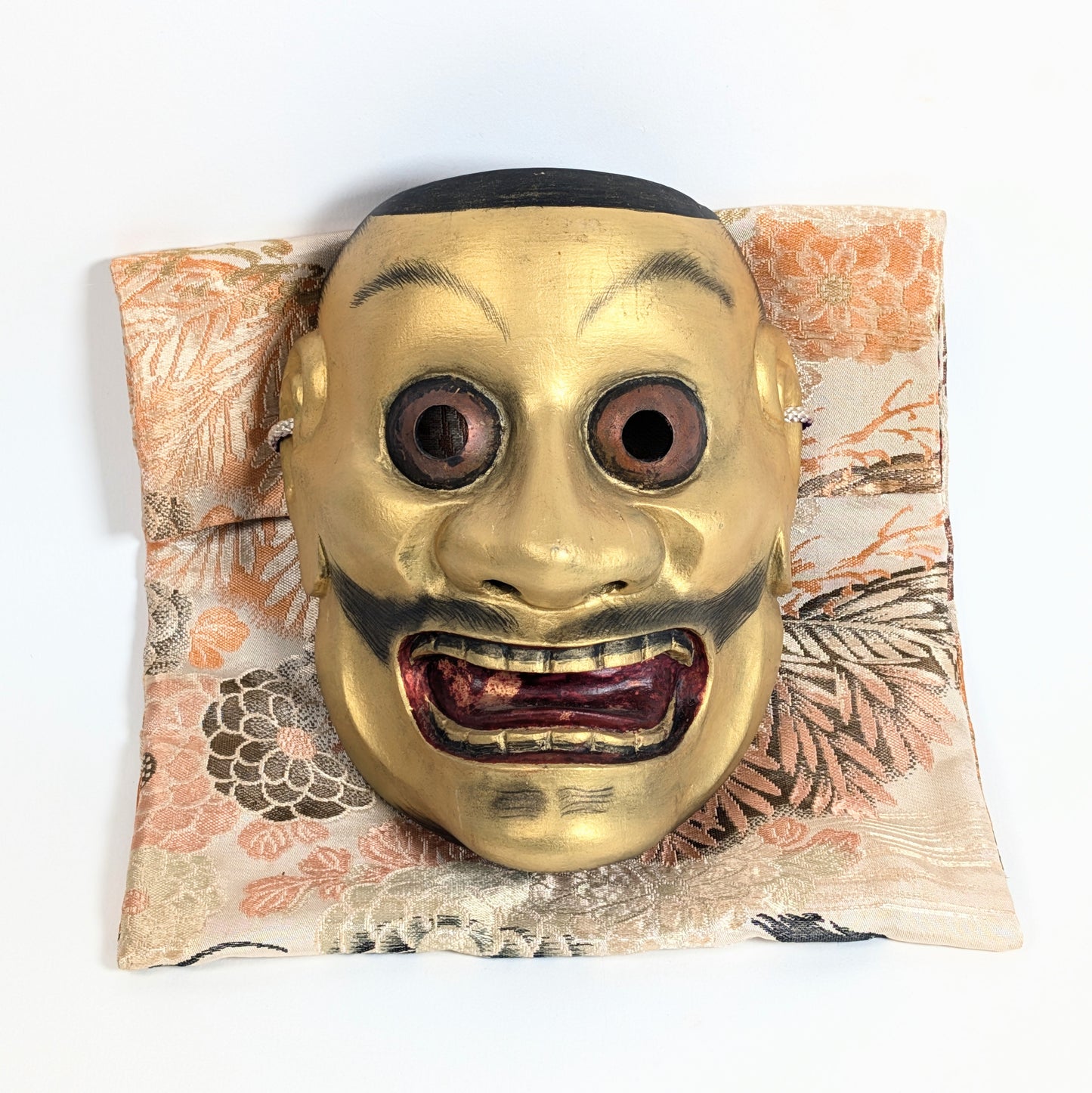 Masque Nô japonais Ōtobide 大飛出 en bois sculpté et doré présenté sur sa pochette traditionnelle en soie japonaise
