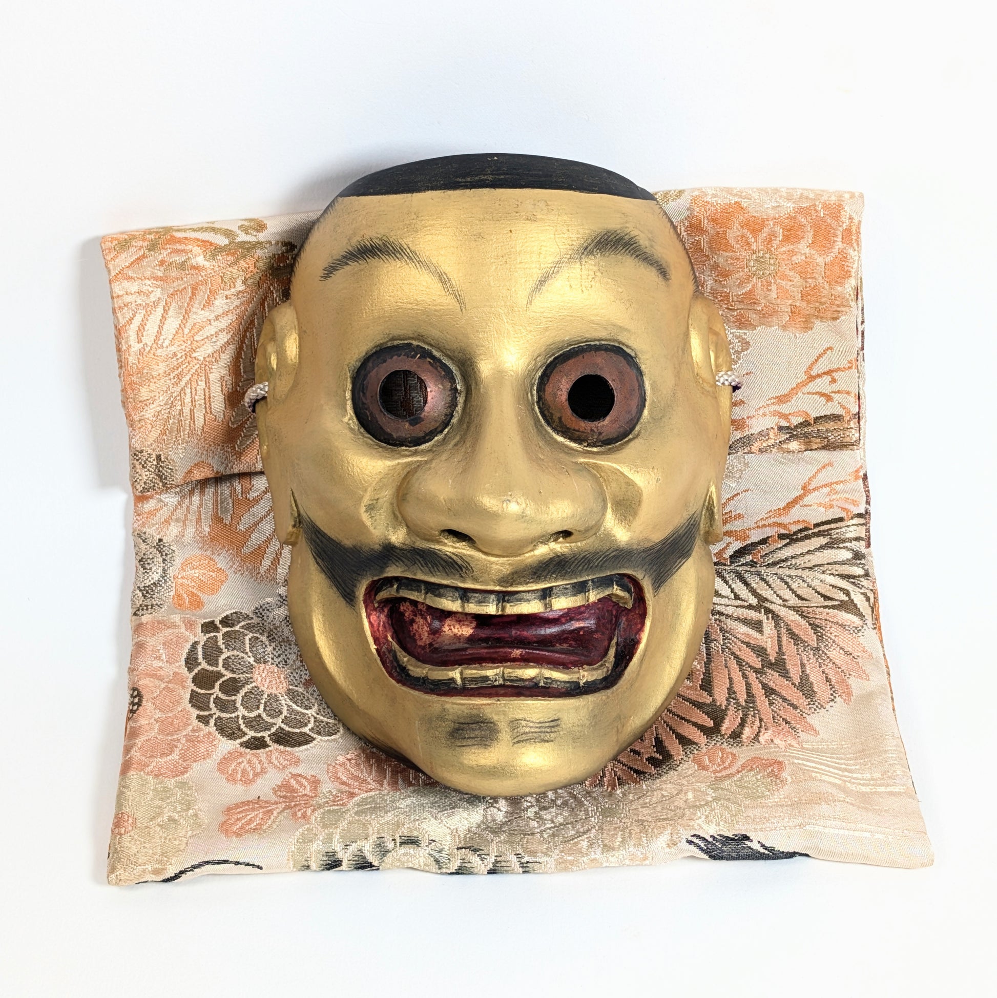 Masque Nô japonais Ōtobide 大飛出 en bois sculpté et doré présenté sur sa pochette traditionnelle en soie japonaise
