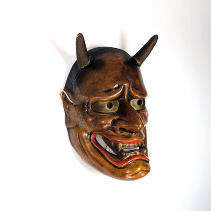 Vue de profil d’un masque de théâtre Nô japonais ancien avec cornes, lumière latérale douce