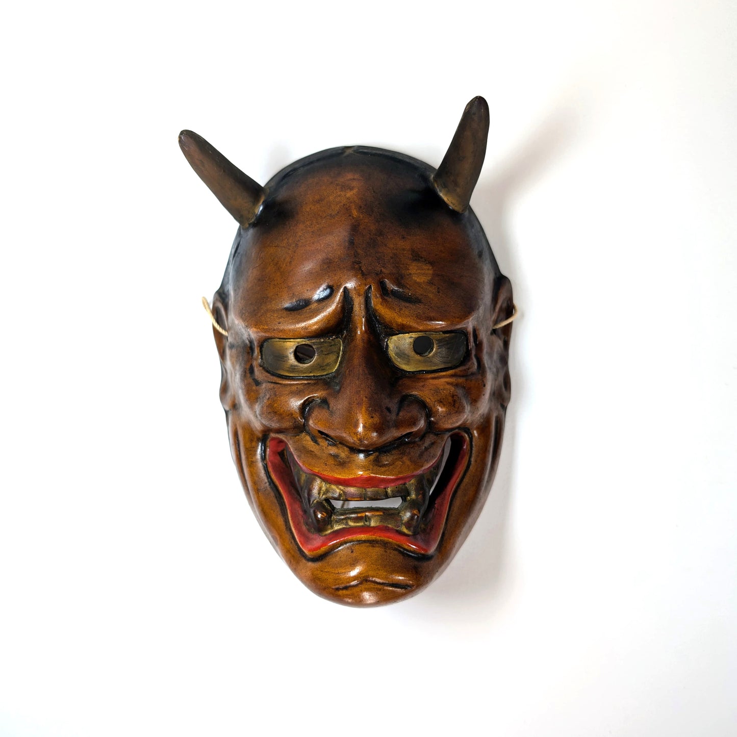 Masque Nô japonais représentant un démon oni, photographié en plongée avec éclairage bas et haut