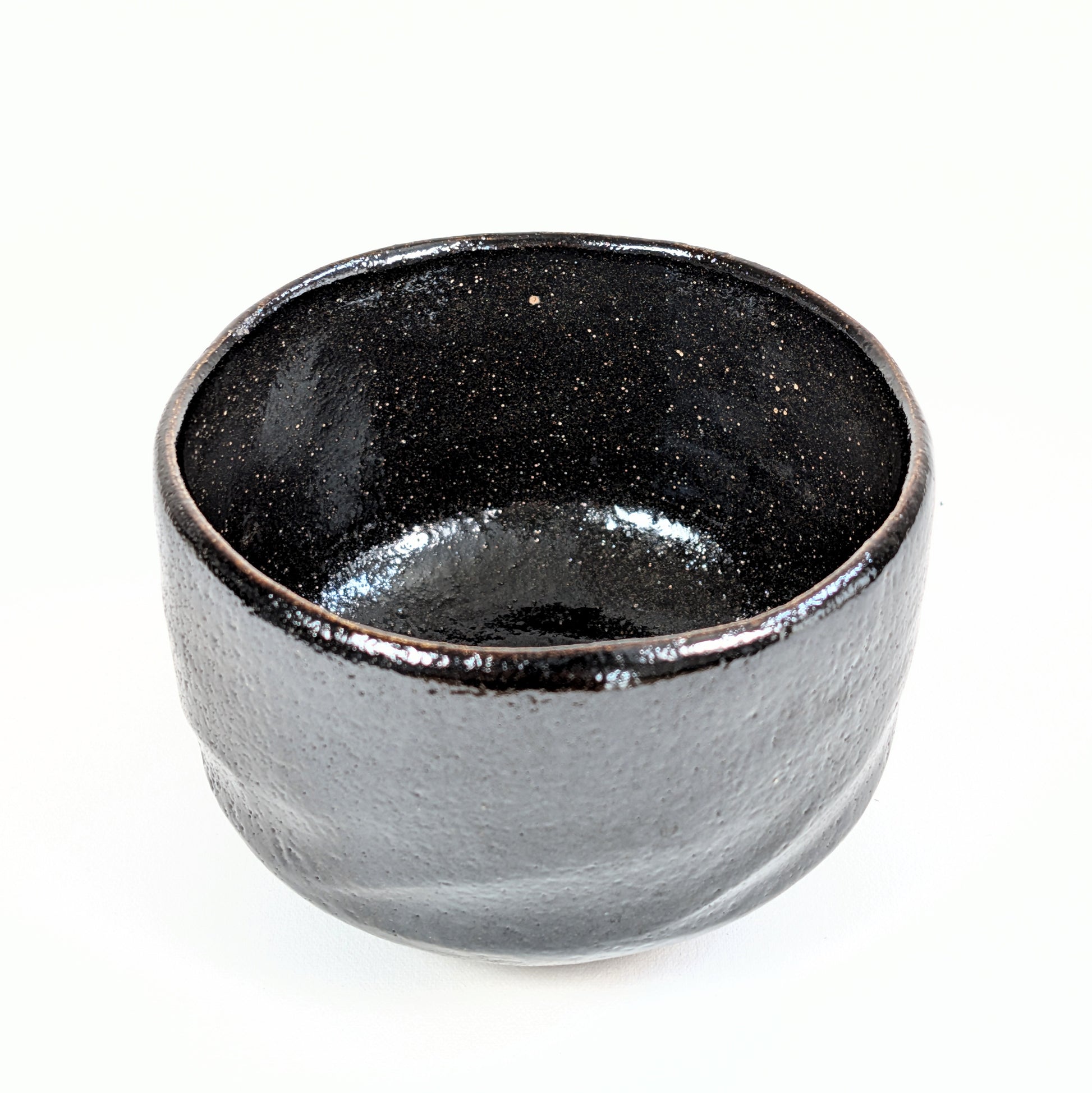 Vue intérieure du matcha chawan 抹茶碗 en céramique japonaise artisanale, avec émail noir profond et moucheté.
