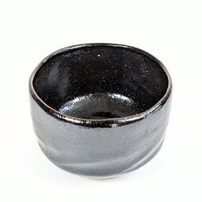 Vue intérieure du matcha chawan 抹茶碗 en céramique japonaise artisanale, avec émail noir profond et moucheté.

