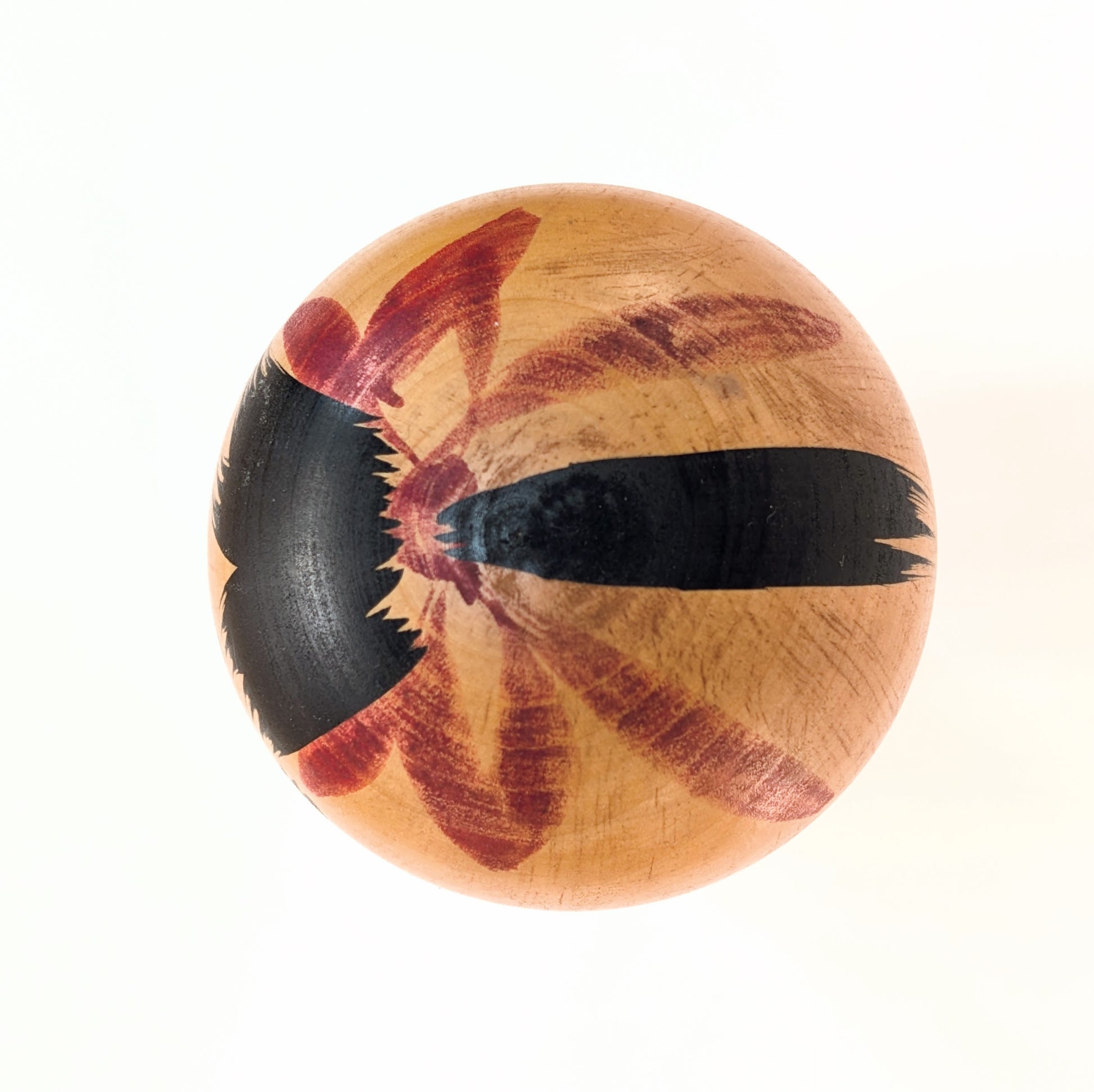 Motif traditionnel peint sur le dessus de la tête d’une kokeshi japonaise ancienne Usuki Hakuhō