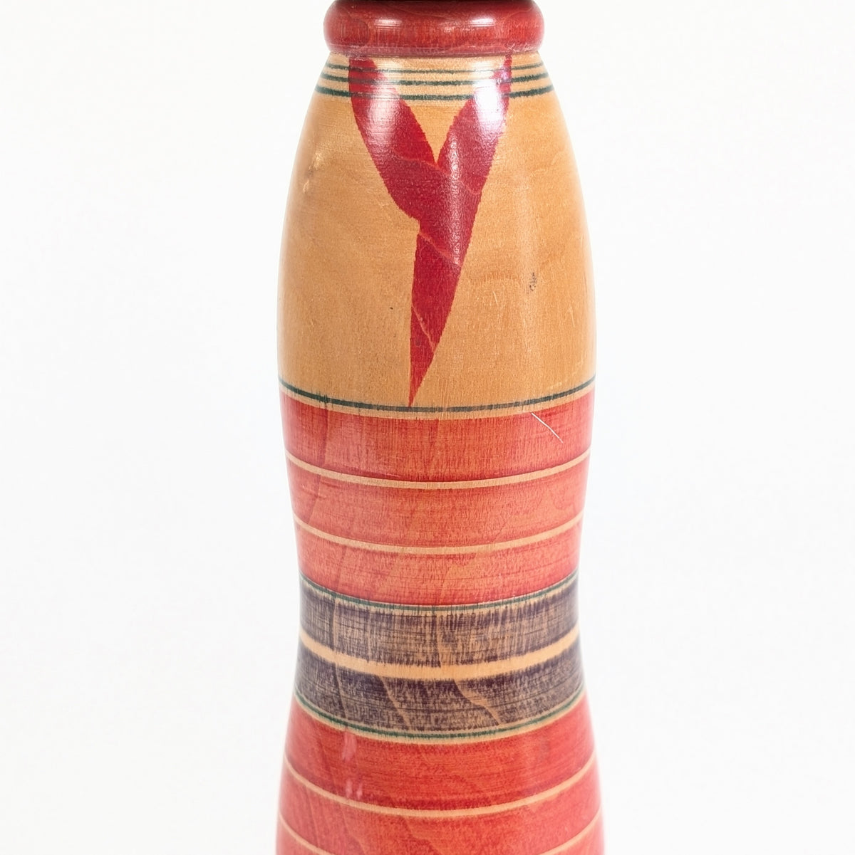 Détail du motif de kimono rouge et jaunes et des bandes peintes au tour d’une kokeshi Yajiro japonaise des années 1970