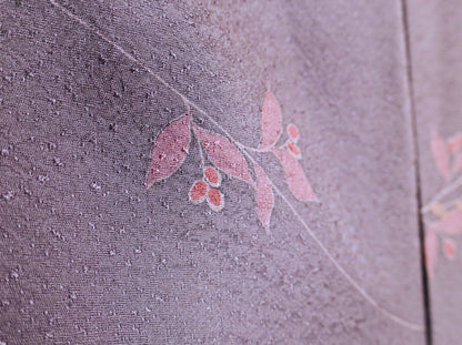 Gros plan du motif nanten rose avec feuilles et baies sur un haori japonais en soie violet grisé