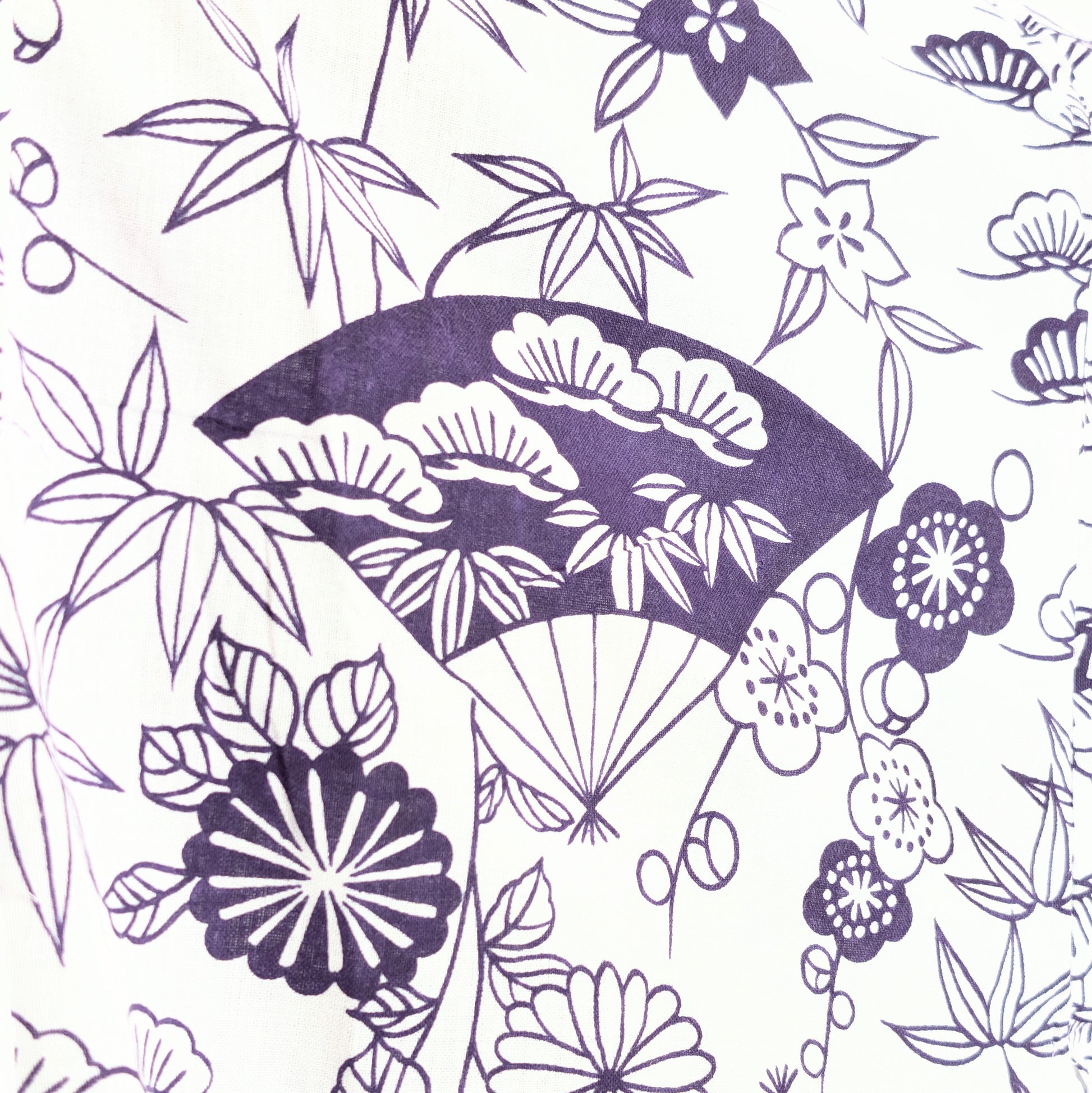 Détail du tissu 100% coton d’un yukata léger japonais blanc et violet, avec motifs éventails sensu, pins matsu, bambous take et fleurs traditionnelles