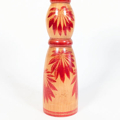 Détail des motifs hishigiku 菱菊, chrysanthèmes rouges peints sur le corps d’une kokeshi traditionnelle Yajirō