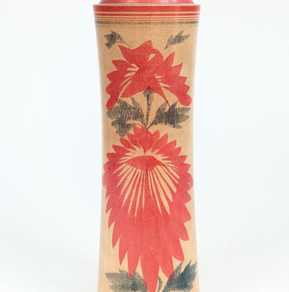 Détail du décor hishigiku 菱菊 sur une kokeshi Naruko, grand motif de chrysanthème rouge caractéristique de cet artisanat japonais.