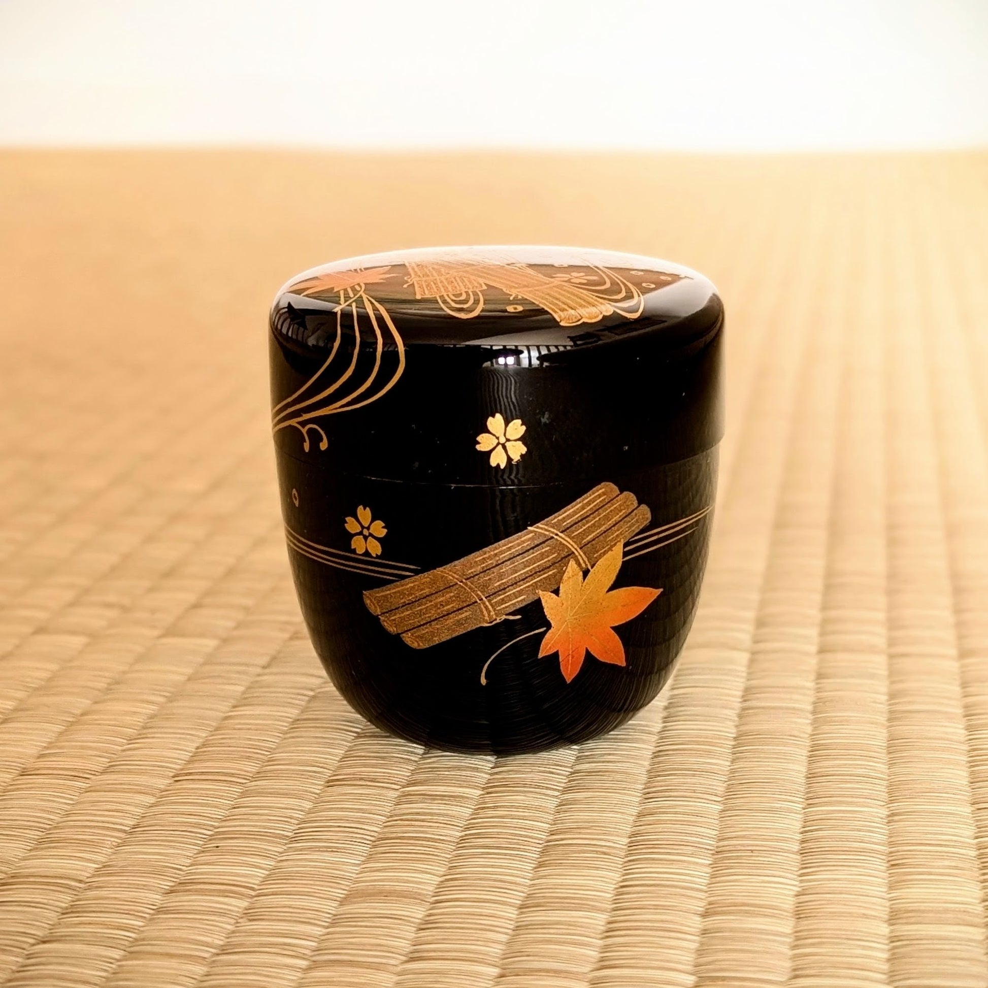 Natsume authentique en laque noire posé sur tatami, décor 花筏 hanaikada en maki-e doré pour cérémonie du thé matcha