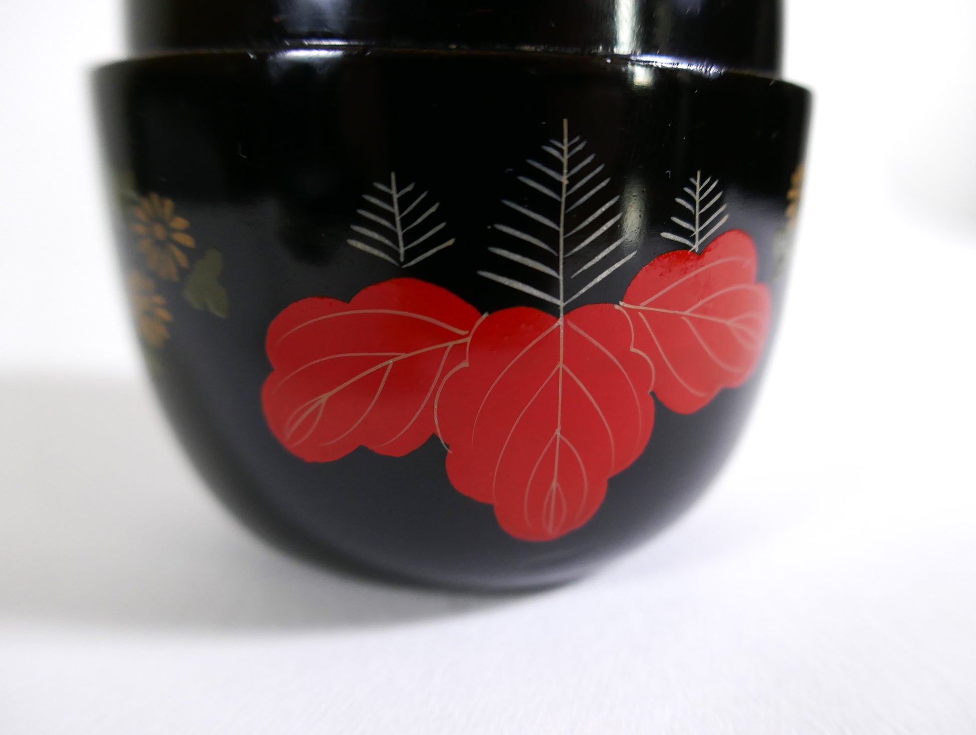 Zoom sur la décoration florale d’un natsume en laque japonaise : paulownia et chrysanthèmes