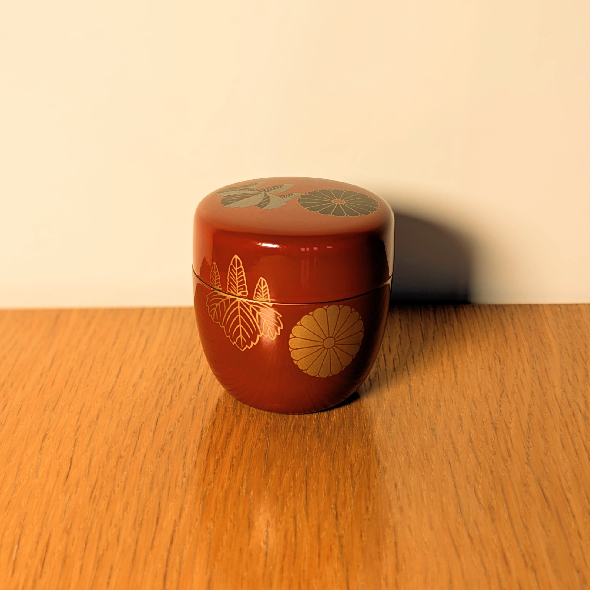 Natsume en laque rouge présenté en décoration japonaise, motifs kiku et kiri dorés sur boîte à matcha vintage authentique