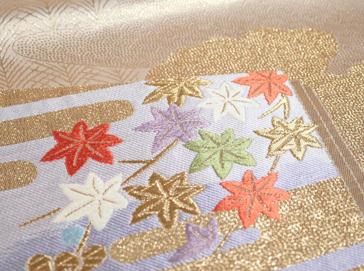 Détail de feuilles d’érable momiji brodées sur un obi japonais en soie, bleu lavande et fils dorés
