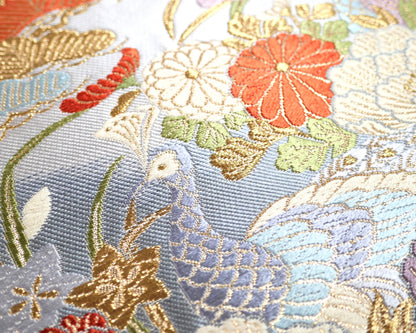 Paon kujaku entouré de pivoines botan et fleurs japonaises sur un obi en soie bleu ciel et brocart doré