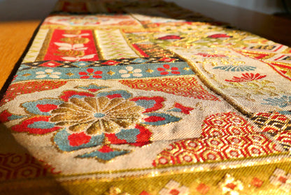 Détail sur un chrysanthème multicolore tissé sur fond doré d’un obi japonais