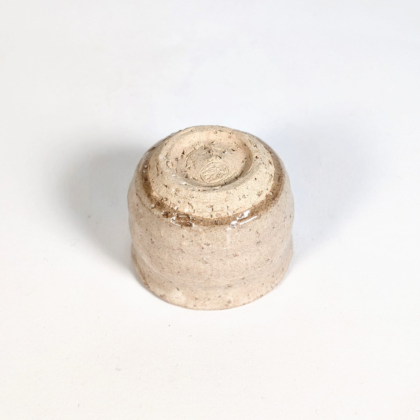 Dessous d’un ochoko, tasse à saké japonaise en Hagi-yaki montrant le pied et la finition artisanale de la céramique