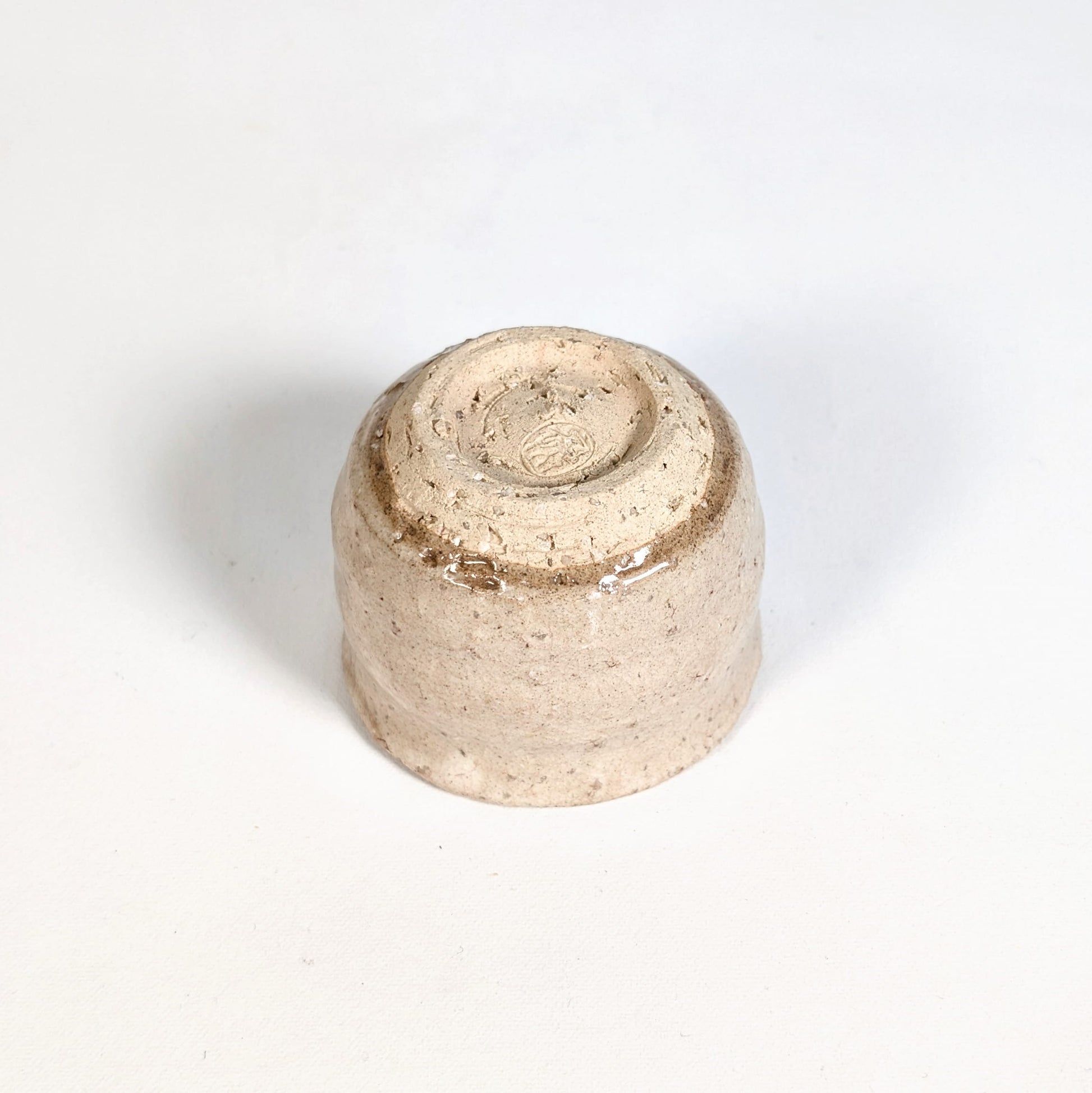 Dessous d’un ochoko, tasse à saké japonaise en Hagi-yaki montrant le pied et la finition artisanale de la céramique