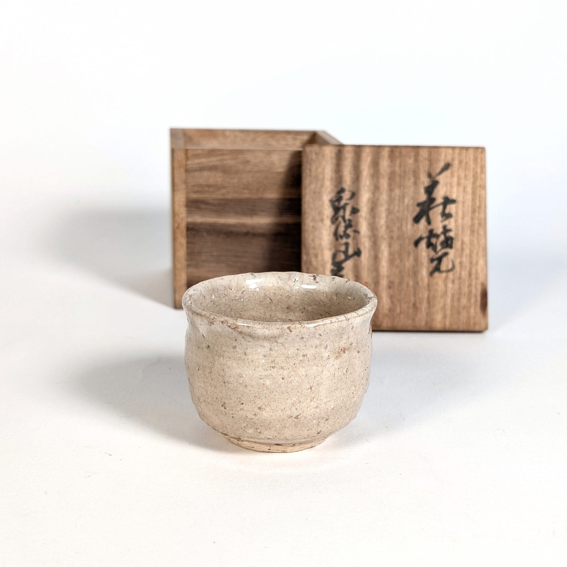 Ochoko japonais, tasse a saké, en Hagi-yaki devant tomobako calligraphié, poterie artisanale signée Yoshiga Taiga four senryuzan