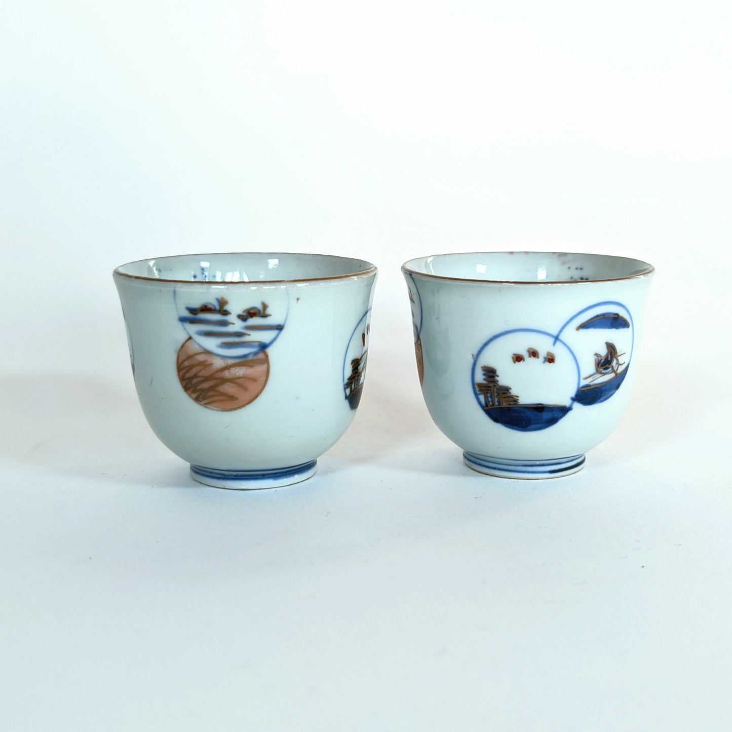 Paire de guinomi anciens en porcelaine Arita Hizen, décor de paysages en médaillons, période Edo tardif.