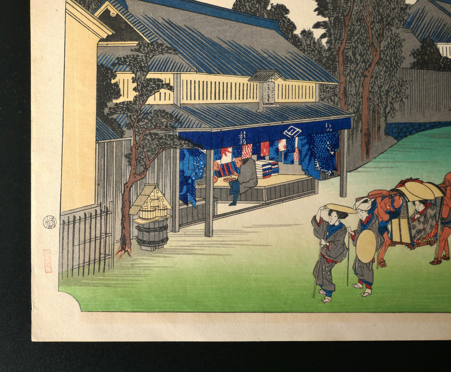 Partie gauche de l’ukiyo-e de Hiroshige à Narumi-juku avec boutique de tissus teints et voyageurs, estampe japonaise ancienne du Tōkaidō
