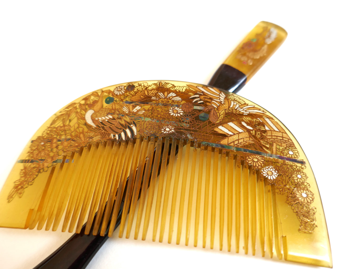 Gros plan du peigne kushi japonais en imitation bekko, décor laqué maki-e doré, travail artisanal Shōwa.