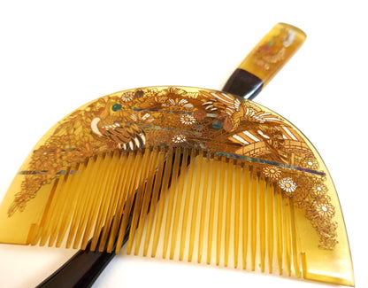 Gros plan du peigne kushi japonais en imitation bekko, décor laqué maki-e doré, travail artisanal Shōwa.