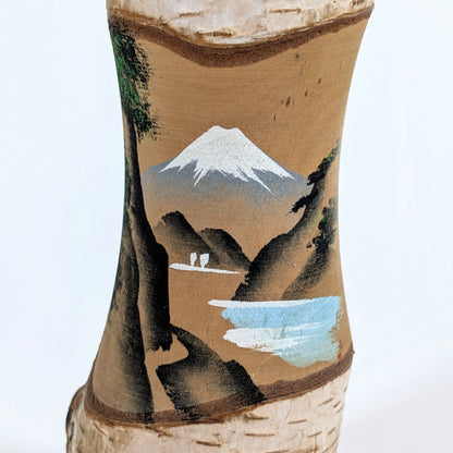 Détail de la peinture artisanale représentant le Mont Fuji sur une kokeshi japonaise vintage.