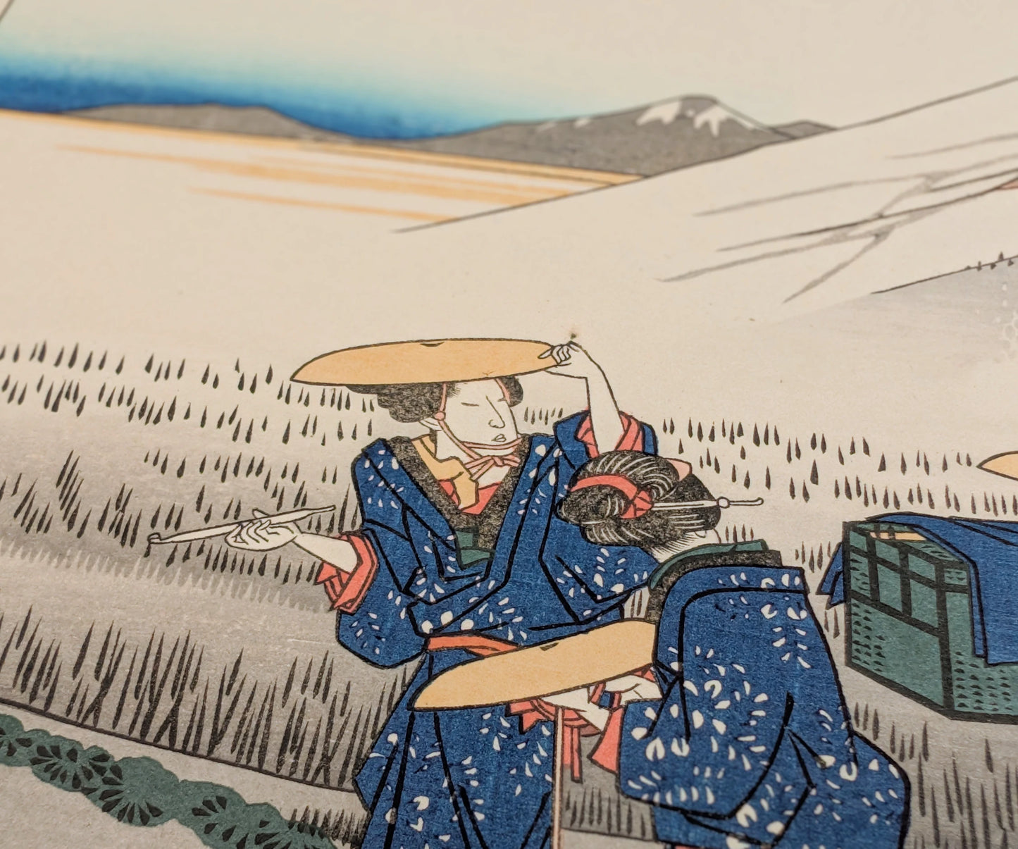 Personnage en kimono bleu dans une estampe japonaise ukiyo-e de Hiroshige, scène de voyage sur le Tokaido
