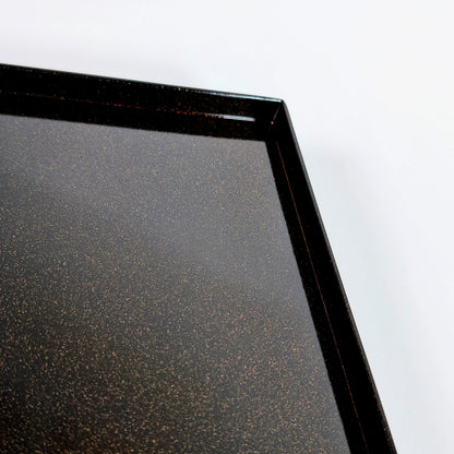 Plateau de boîte en laque noire avec texture nashiji scintillante, vue sur l’angle et le rebord.