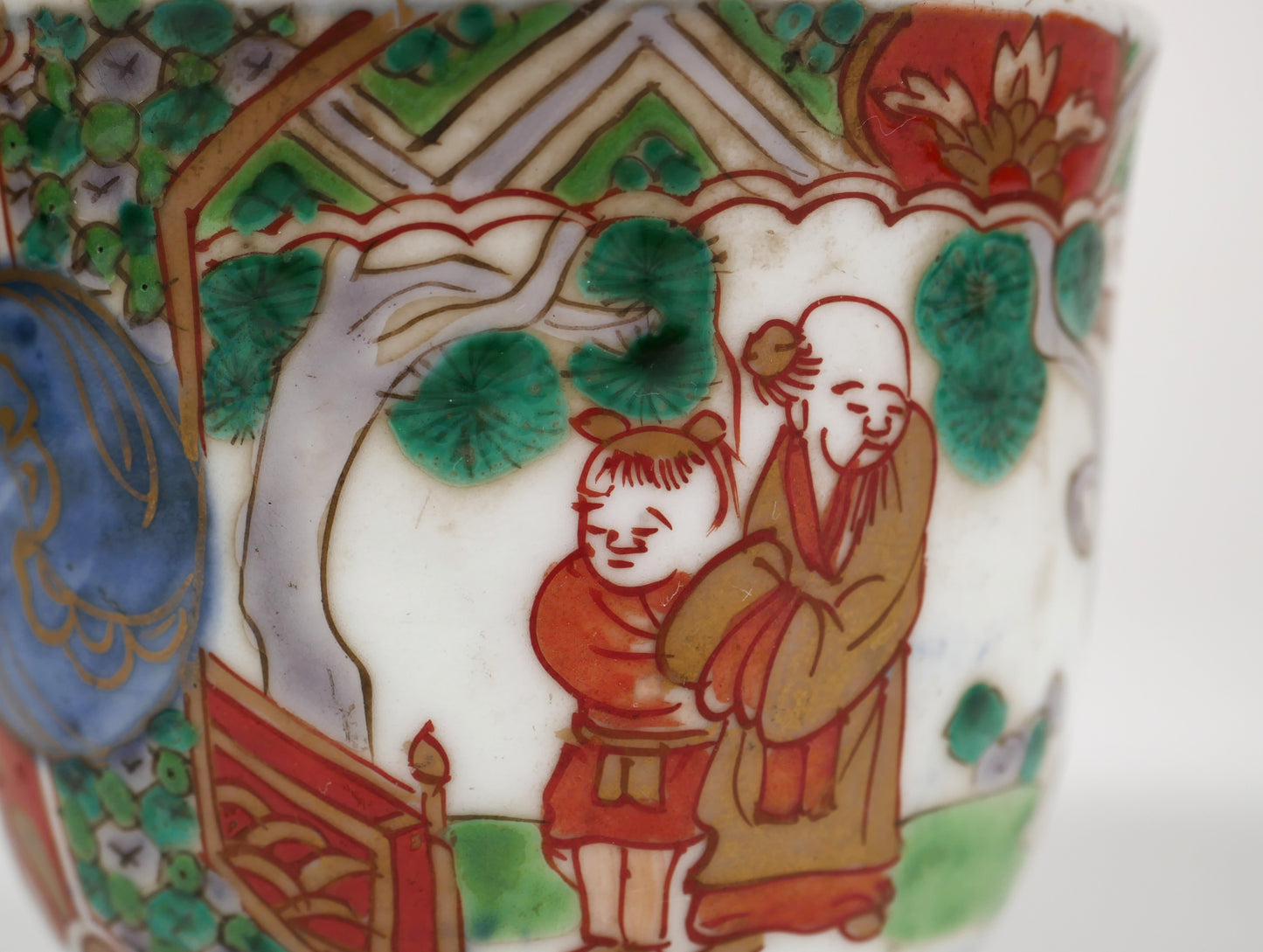 Gros plan du décor Tōjin-zu avec lettré chinois et enfant karako sur une tasse japonaise Imari ancienne Edo