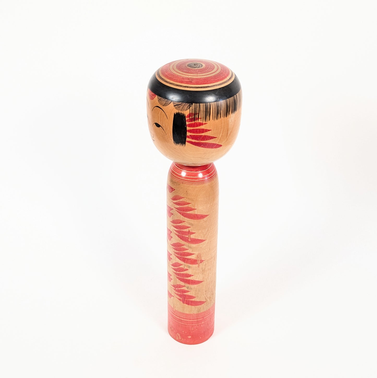 Poupée japonaise en bois de type kokeshi Yajirō, vue de trois quarts gauche, décorée de motifs kasane-giku rouges.