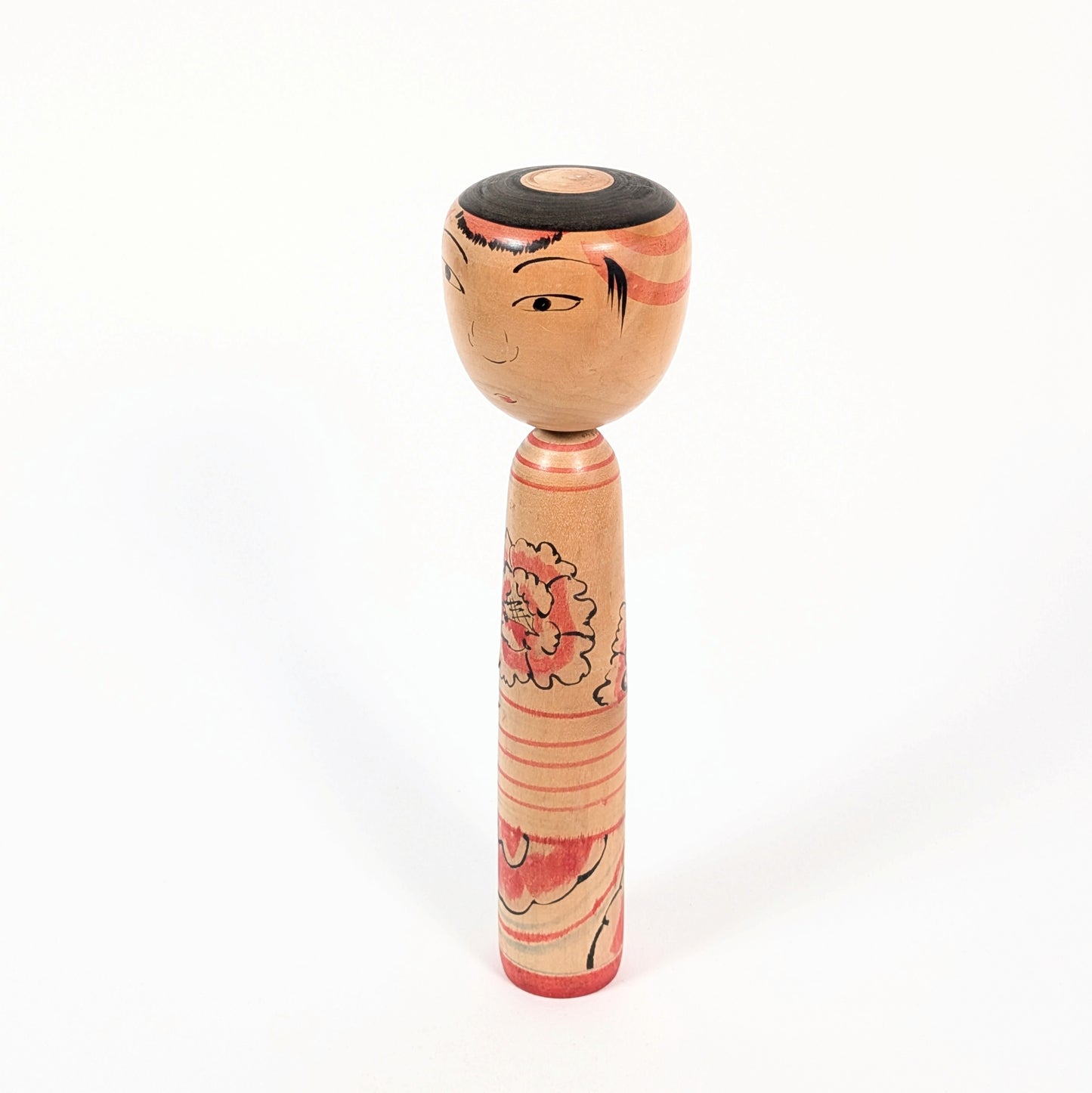Poupée kokeshi japonaise en bois, visage typique Nakanosawa au regard expressif.