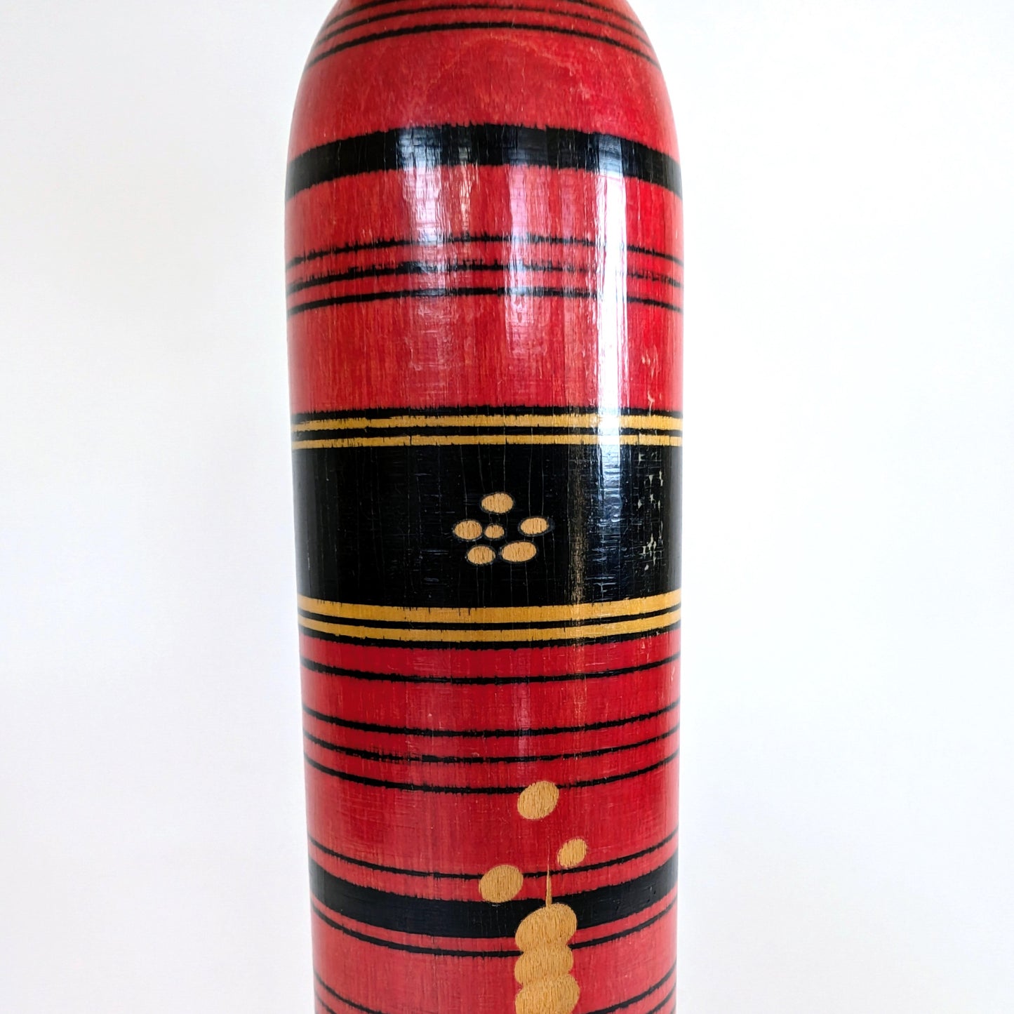 Motif central noir et or sur une poupée japonaise kokeshi style Shingata, artisanat de Sasaki Katsumi