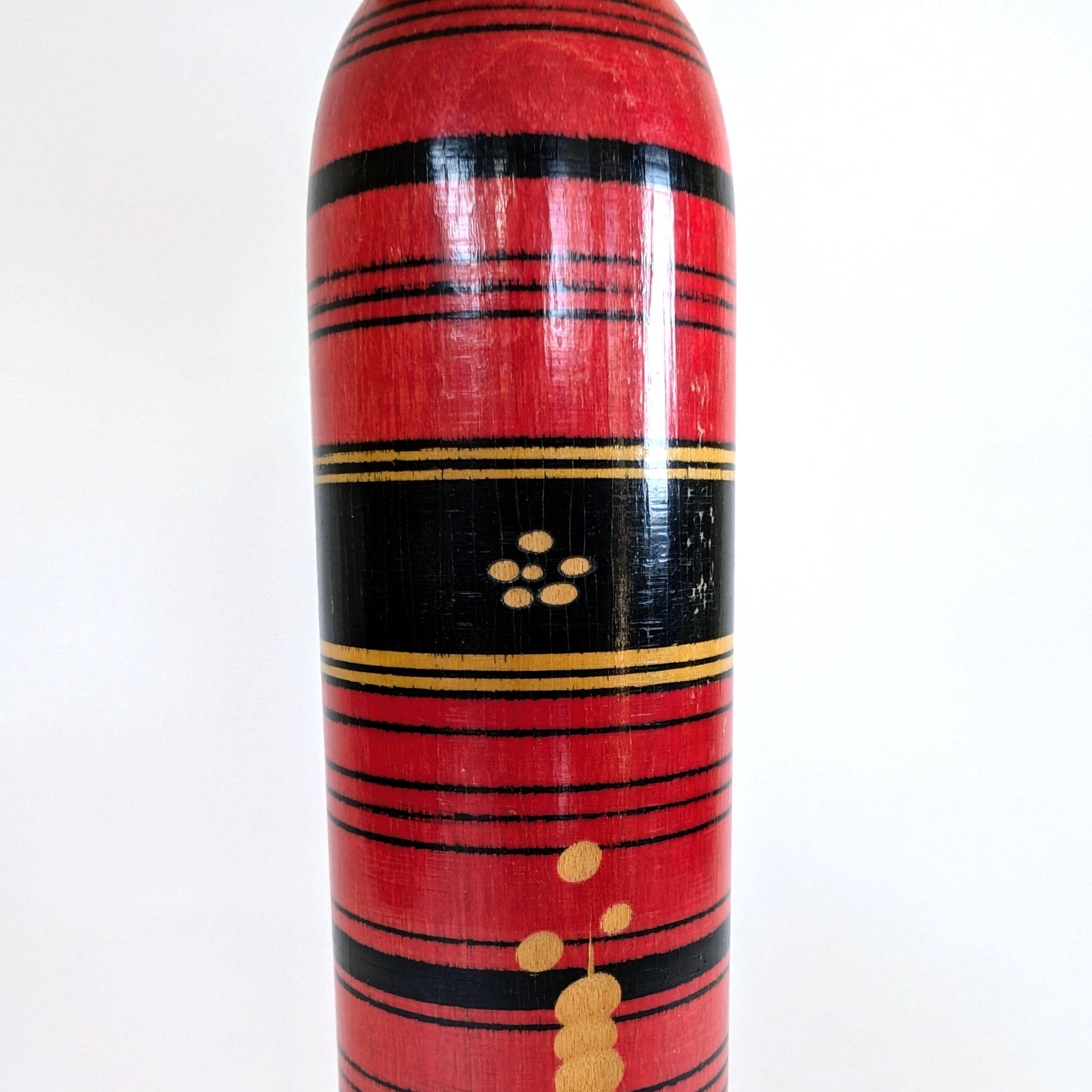 Motif central noir et or sur une poupée japonaise kokeshi style Shingata, artisanat de Sasaki Katsumi