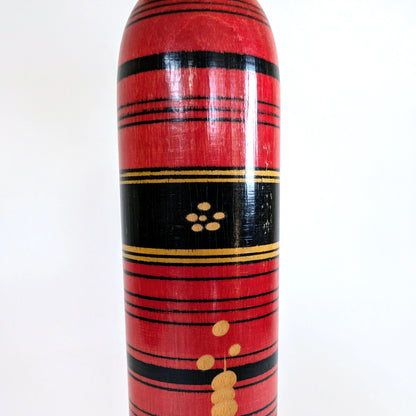 Motif central noir et or sur une poupée japonaise kokeshi style Shingata, artisanat de Sasaki Katsumi