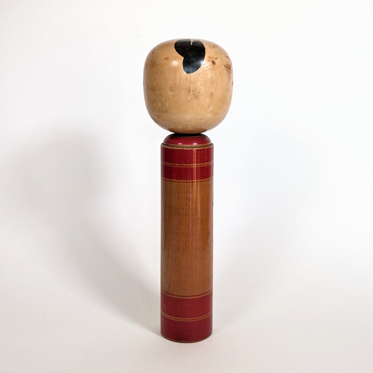 Vue arrière d’une poupée japonaise kokeshi shingata ancienne par Kiyohara Takao, bois tourné et patine
