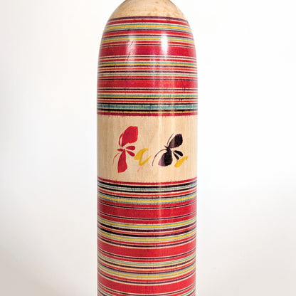 Détail papillons sur poupée japonaise kokeshi Togatta Sakuta Koichi, artisanat mingei