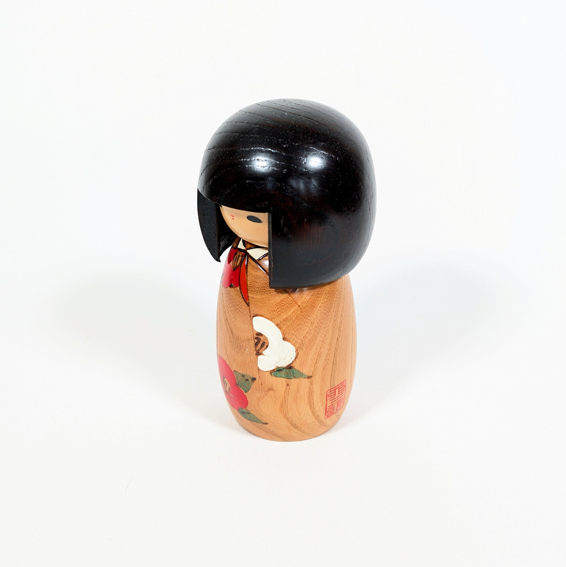 Kokeshi vintage Usaburo Haru no uta vue de profil avec sceau rouge, décor tsubaki et kimono fleuri
