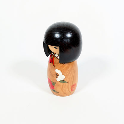 Kokeshi vintage Usaburo Haru no uta vue de profil avec sceau rouge, décor tsubaki et kimono fleuri