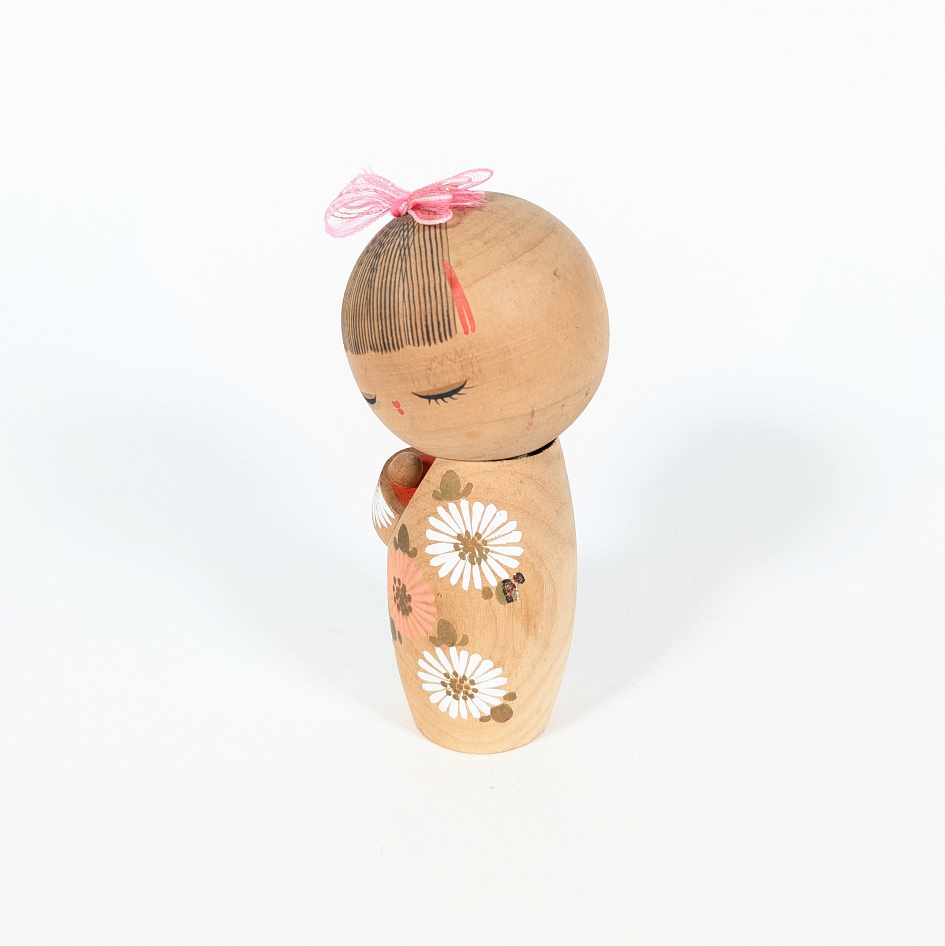 poupée kokeshi japonaise artisanale avec ruban rose cheveux peints style sosaku hinagiku visage paisible