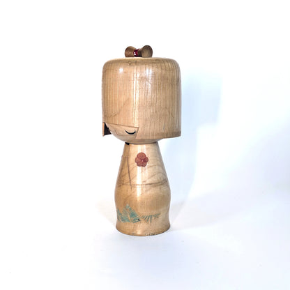 Profil gauche d’une kokeshi artisanale japonaise Ueda Izumi, bois gravé et peint.