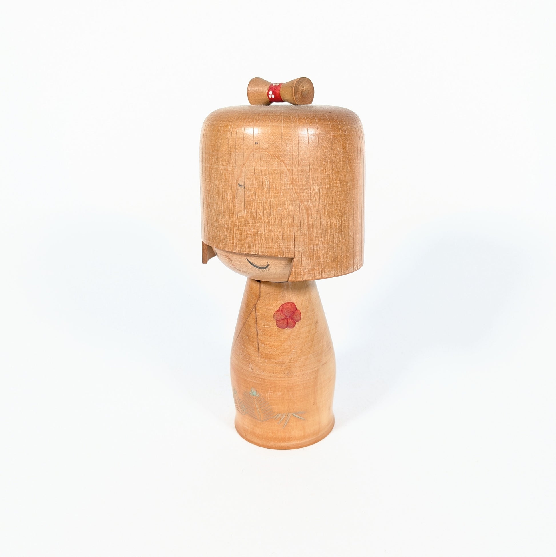Poupée kokeshi japonaise signée Ueda Izumi, art populaire japonais en bois avec expression douce et motif floral rouge