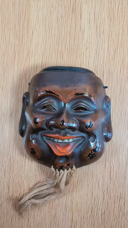 Masque japonais de Daikoku 大黒 en laque sèche kanshitsu, présenté sous plusieurs angles pour montrer le relief du visage, la finition rouge-noir de type Negoro, la barbe en fibres végétales et le revers textile.