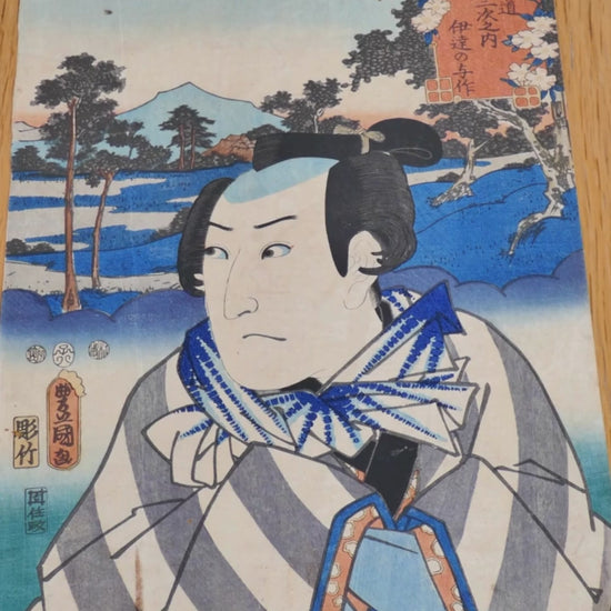 Estampe originale de 1852 signée Utagawa Kunisada (Toyokuni III). Portrait de l’acteur Sawamura Sōjūrō III dans le rôle de Date no Yosaku, héros de kabuki. Belle composition avec Mont Fuji en arrière-plan. Couleurs patinées, tache et usures légères. Impression bois sur papier washi. Série : Les 53 stations du Tōkaidō. Pièce unique.